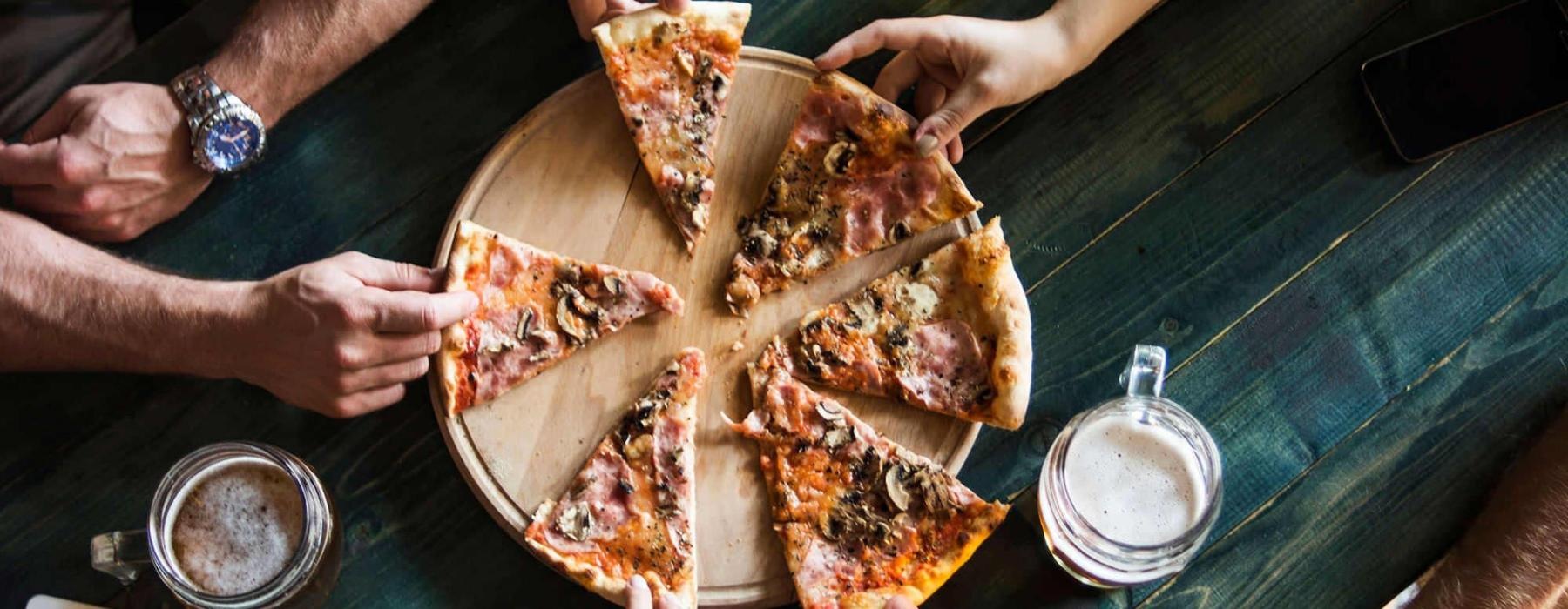 a group of people eating pizza